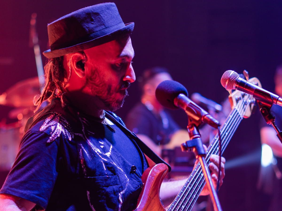 Marcos Rodríguez tocando el bajo en vivo bajo luces rojas, como bajista de sesión