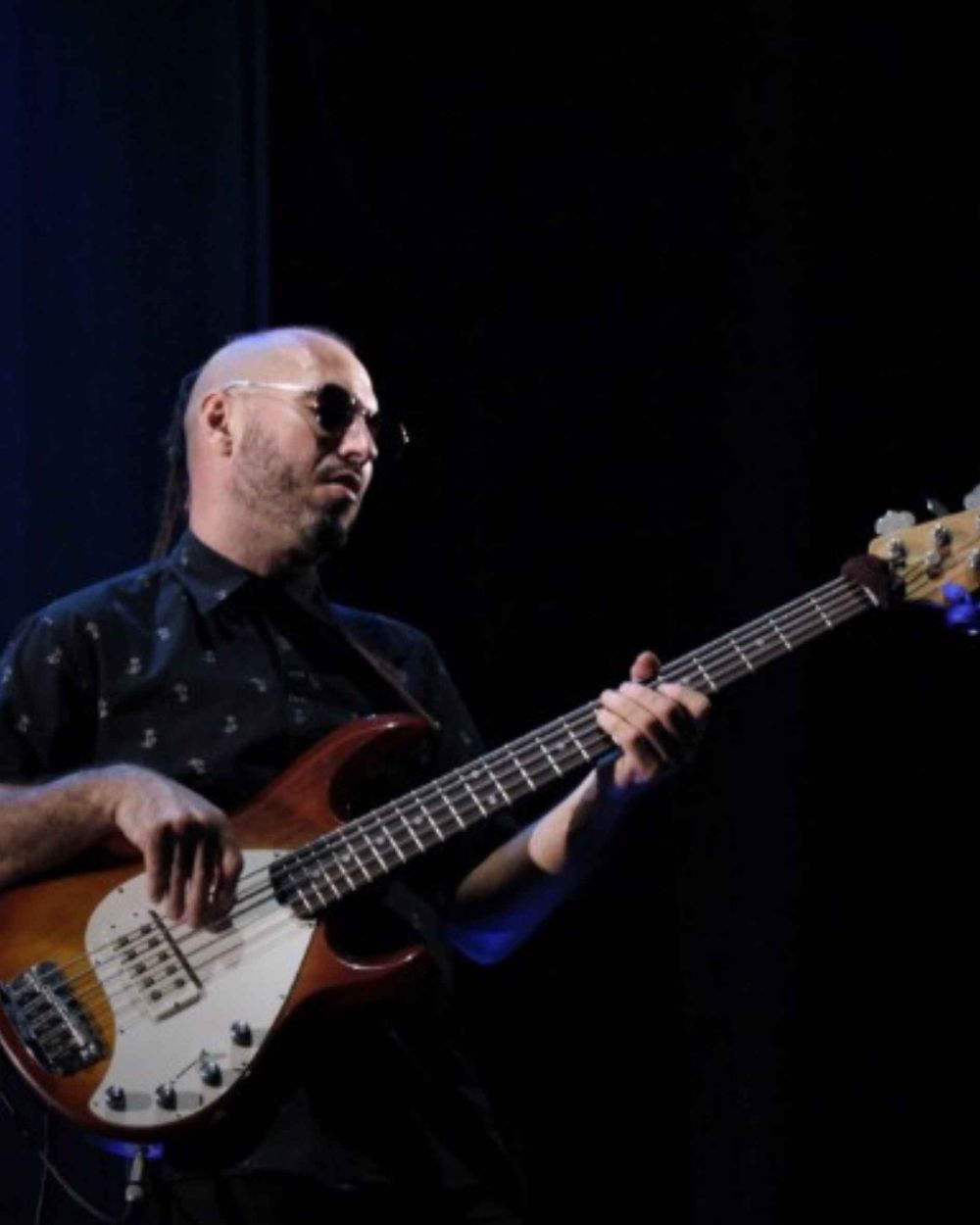 Marcos Rodríguez tocando el bajo en escena, luz baja de show