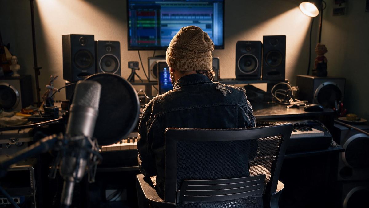 Sesión de scoring en el estudio: timeline de audio en pantalla, monitores y teclado